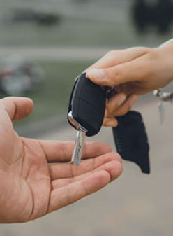 Person handing over a car key to car donation charity