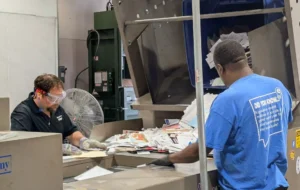 Workers processing confidential papers for secure document shredding services in Hampton, VA.