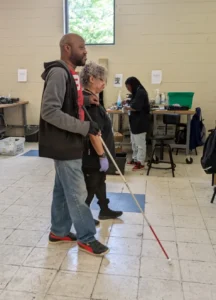 he scene highlights the supportive interaction in a training space for adults with disabilities.